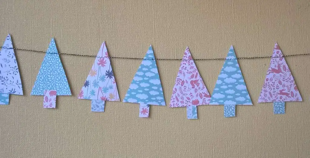 kerst knutselen kind slinger van papieren kerstboompjes